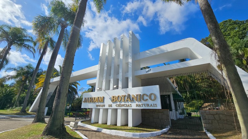 P&oacute;rtico entrada em concreto da cor branca e letras douradas com o nome jardim bot&acirc;nico. 